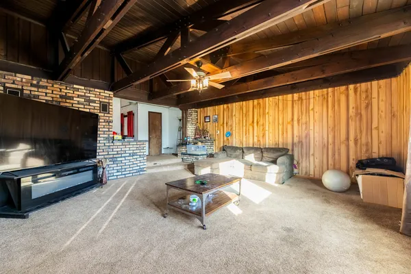 a living room with patio furniture and a flat screen tv