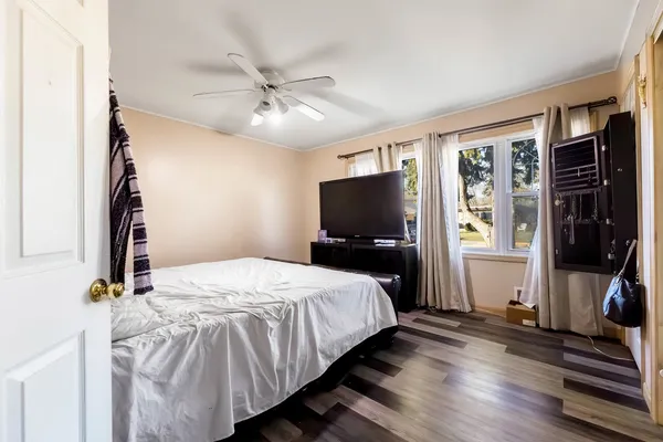 a bedroom with a bed and a flat tv screen on dresser