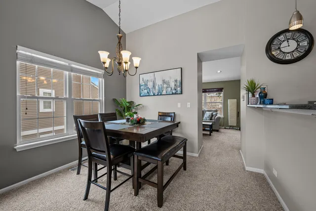 a view of a dining room with furniture and chandelier