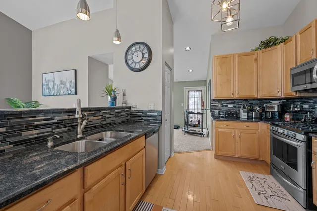 a kitchen with stainless steel appliances granite countertop a stove and cabinets
