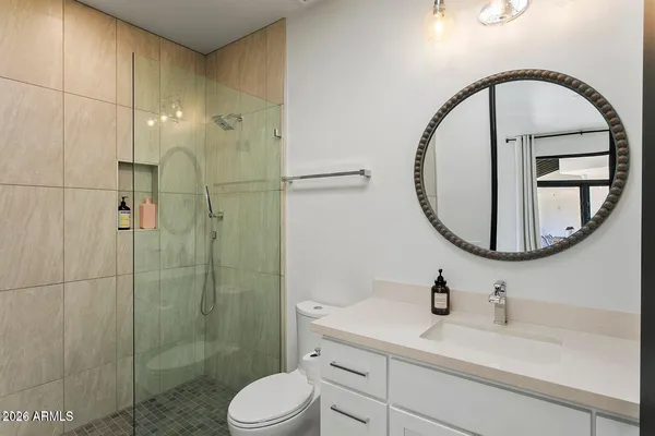 a bedroom with a bed and a large mirror