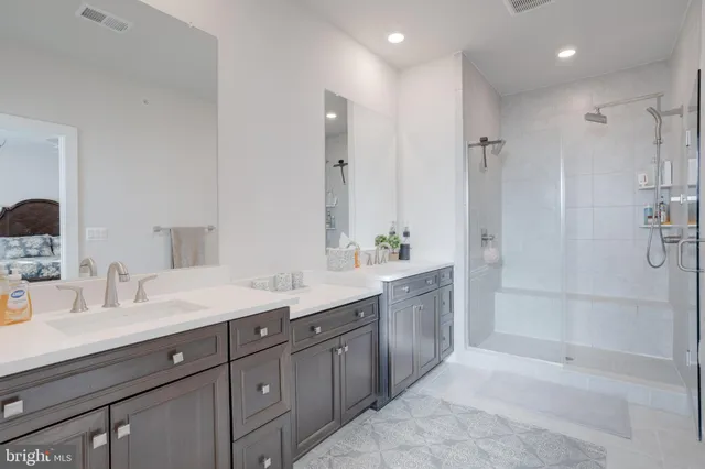 a spacious bathroom with a granite countertop sink mirror and shower