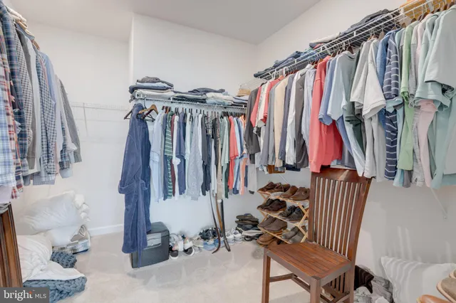 a view of walk in closet with clothes