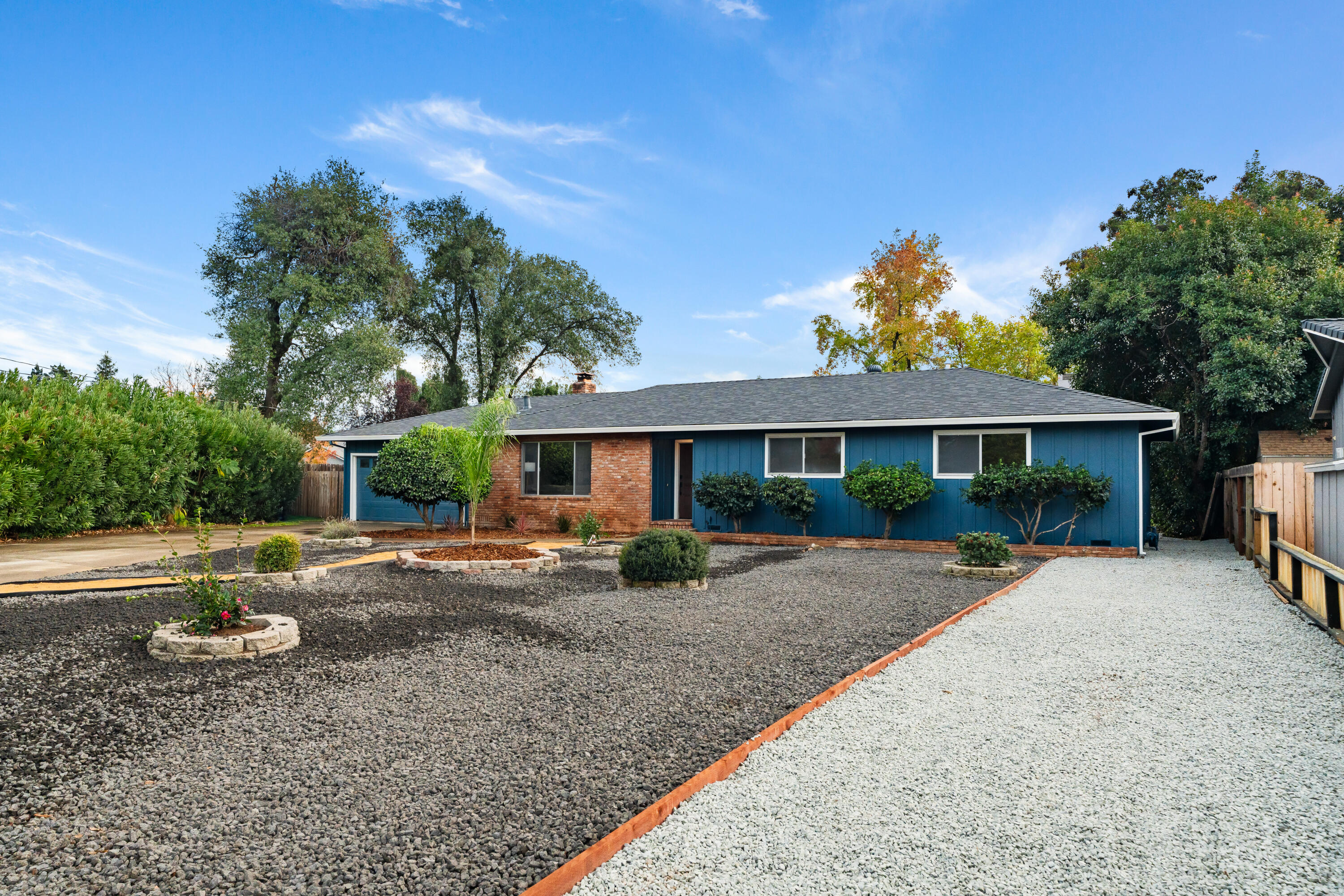 595 Rafael Street Redding, CA 96002 - Photo 4 of 54 a front view of a house with a yard and potted plants