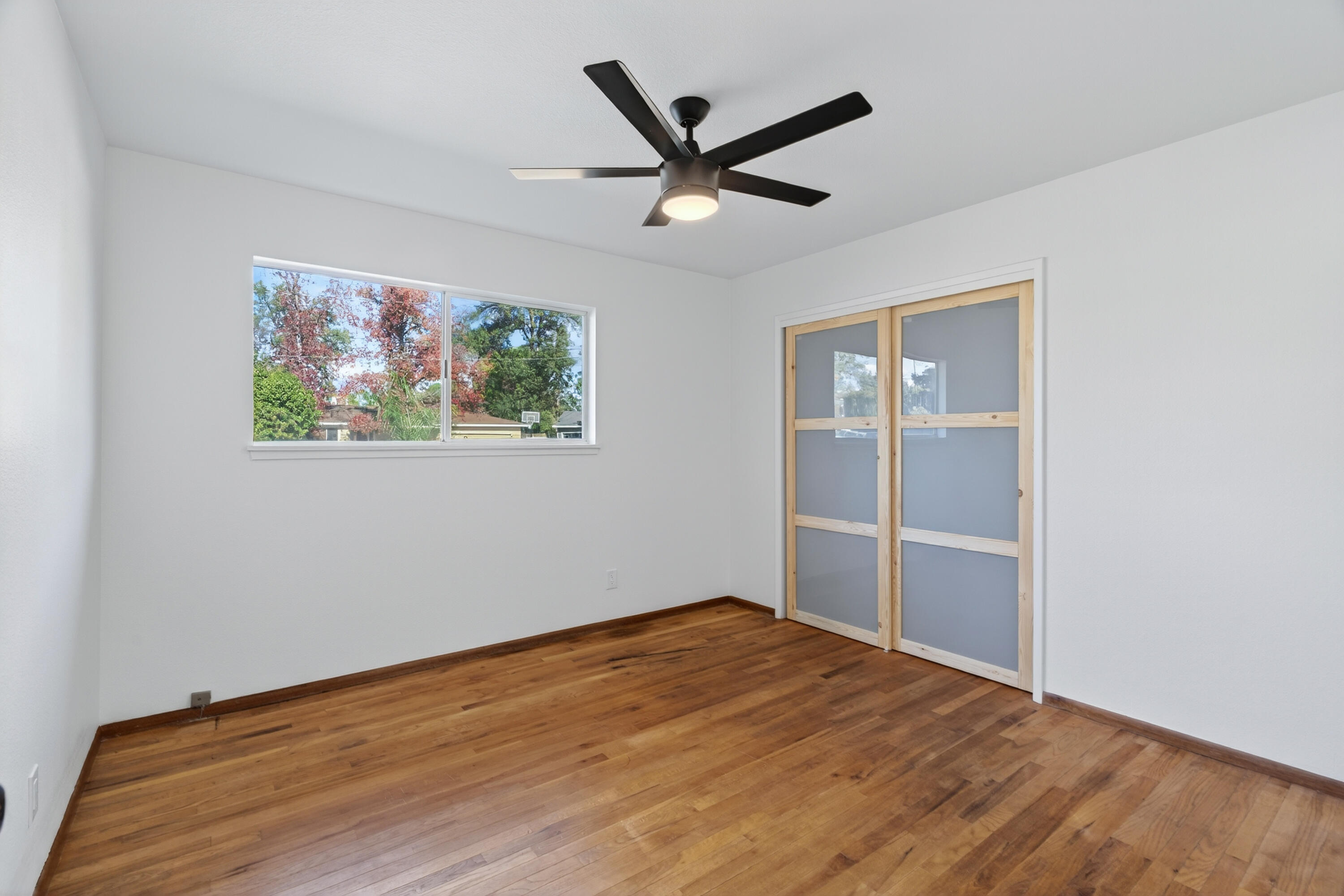 595 Rafael Street Redding, CA 96002 - Photo 44 of 54 a view of a big room with wooden floor a ceiling fan and windows