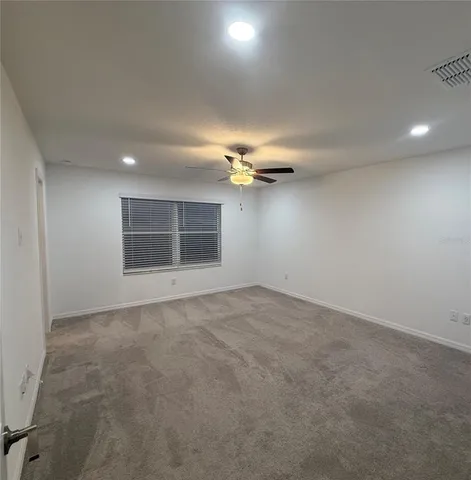 a view of a room with a ceiling fan and window