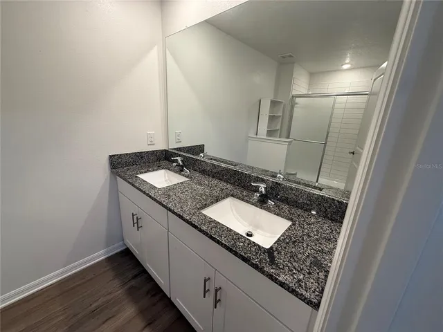 a bathroom with a granite countertop sink and a mirror