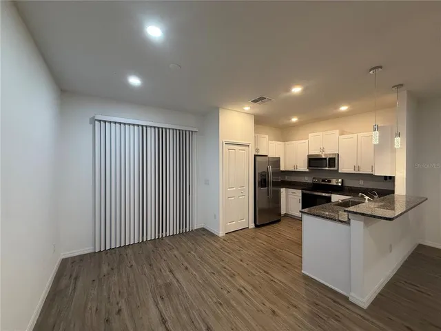 a kitchen with stainless steel appliances granite countertop a refrigerator and a stove top oven