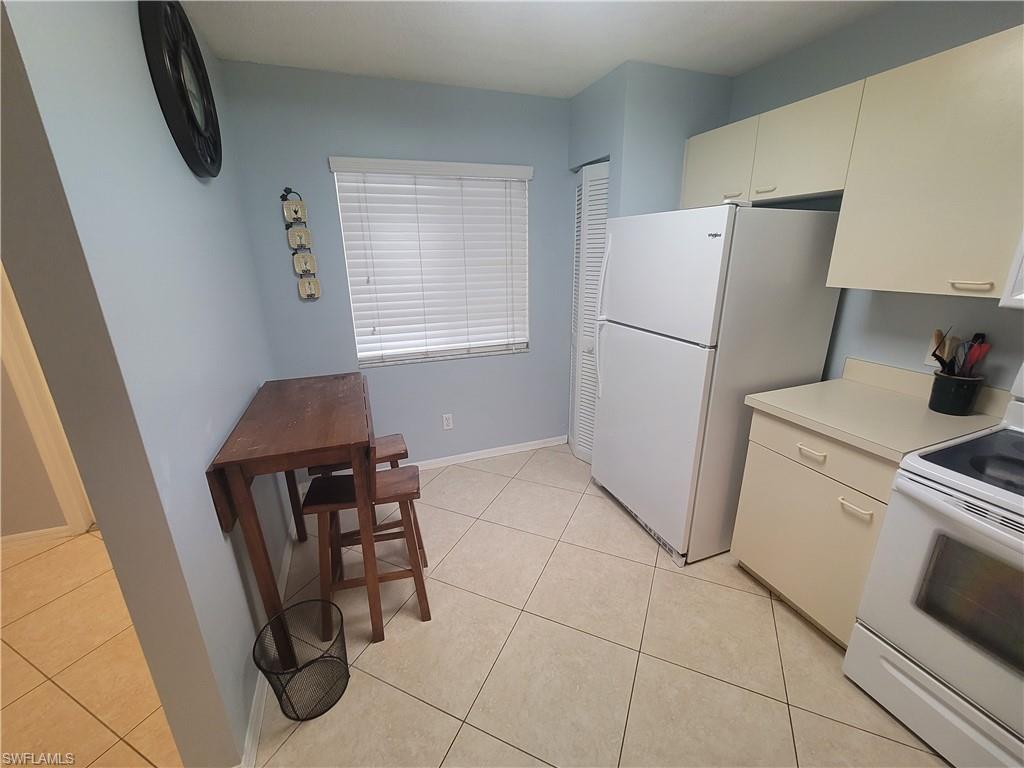 7731 Jewel Lane, Unit 204 Naples, FL 34109 - Photo 12 of 29 a kitchen with a refrigerator and a stove top oven