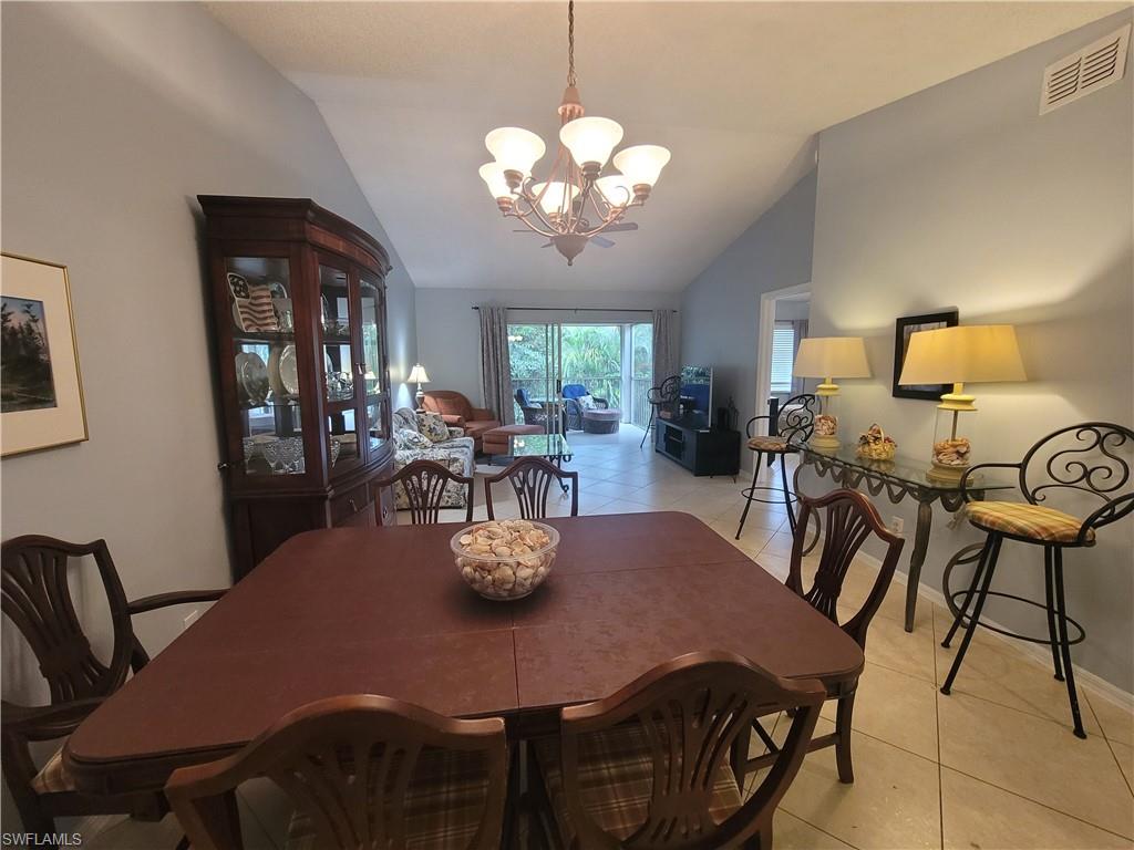 7731 Jewel Lane, Unit 204 Naples, FL 34109 - Photo 13 of 29 a view of a dining room with furniture and chandelier