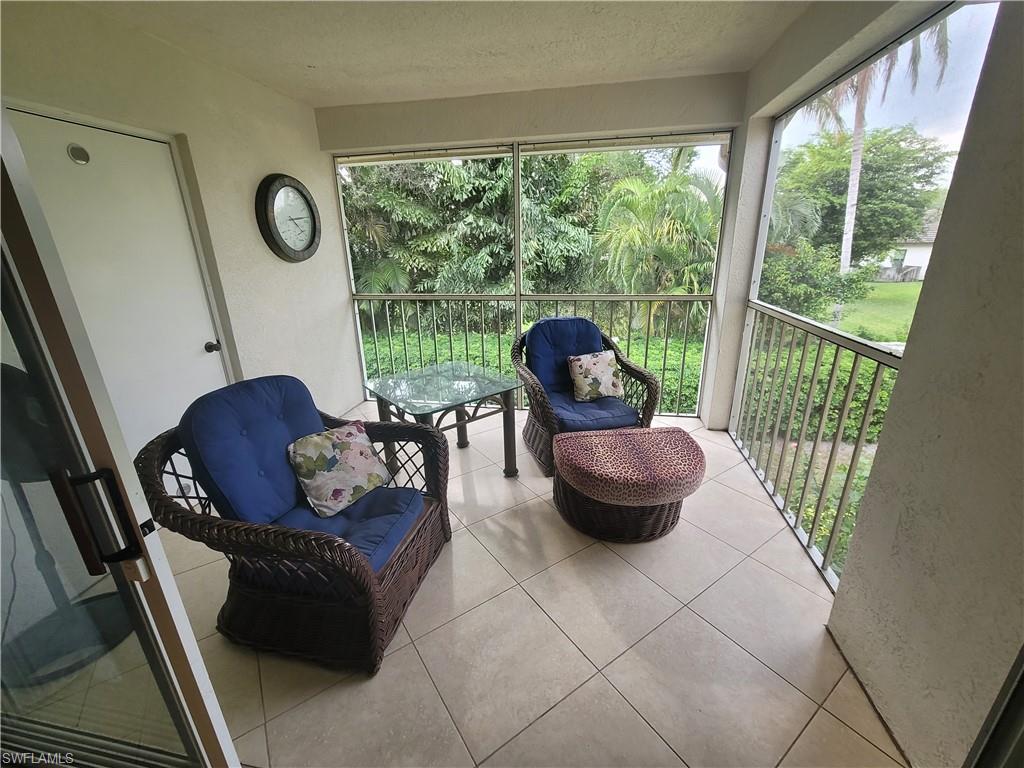 7731 Jewel Lane, Unit 204 Naples, FL 34109 - Photo 23 of 29 a living room with furniture and a floor to ceiling window