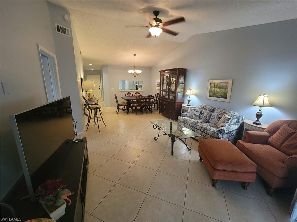 7731 Jewel Lane, Unit 204 Naples, FL 34109 - Photo 3 of 29 a living room with furniture a dining table and a fireplace