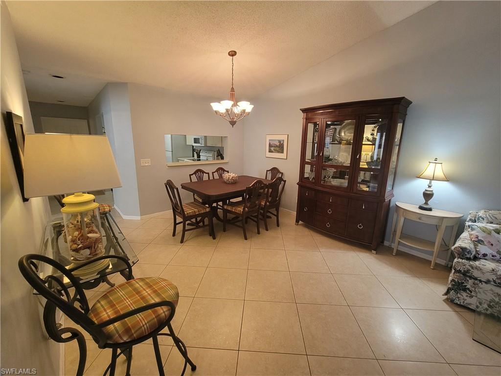 7731 Jewel Lane, Unit 204 Naples, FL 34109 - Photo 5 of 29 a view of a dining room with furniture and chandelier