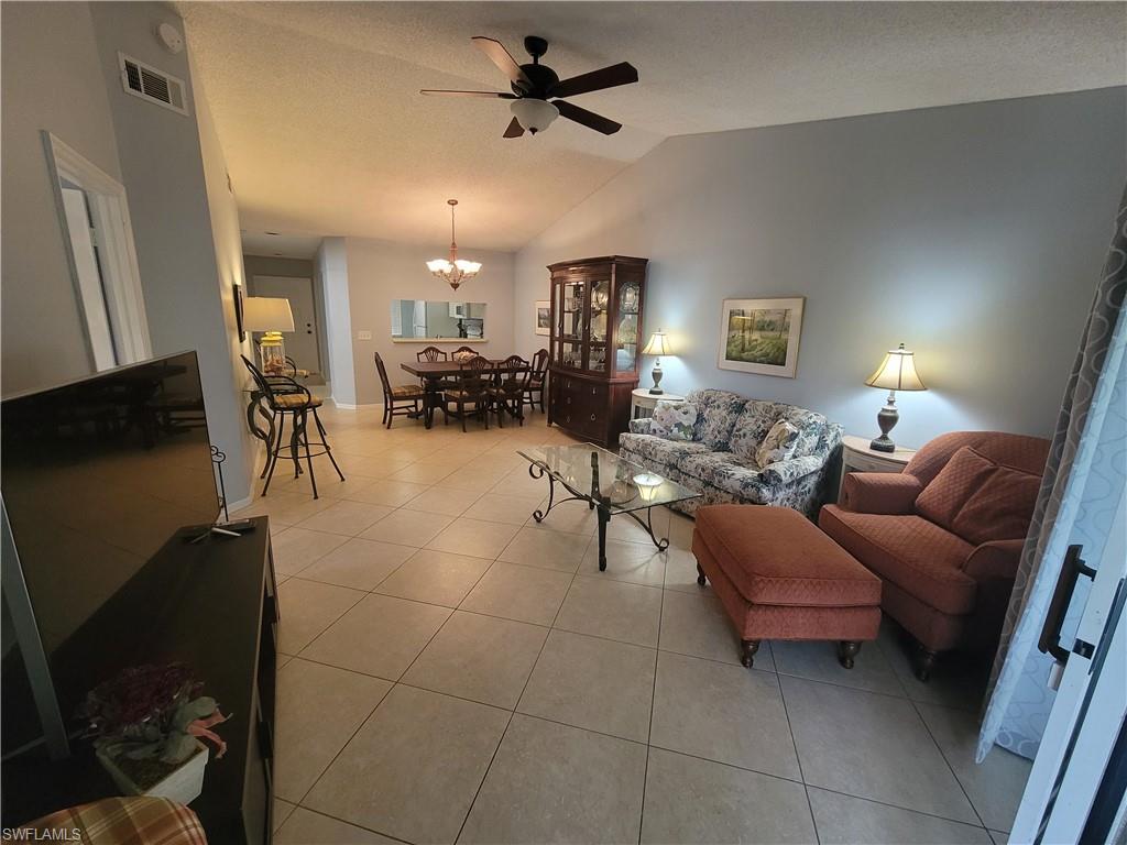 7731 Jewel Lane, Unit 204 Naples, FL 34109 - Photo 7 of 29 a living room with furniture a dining table and a fireplace