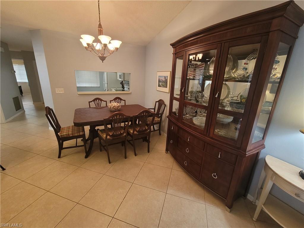 7731 Jewel Lane, Unit 204 Naples, FL 34109 - Photo 9 of 29 a view of a dining room with furniture and chandelier