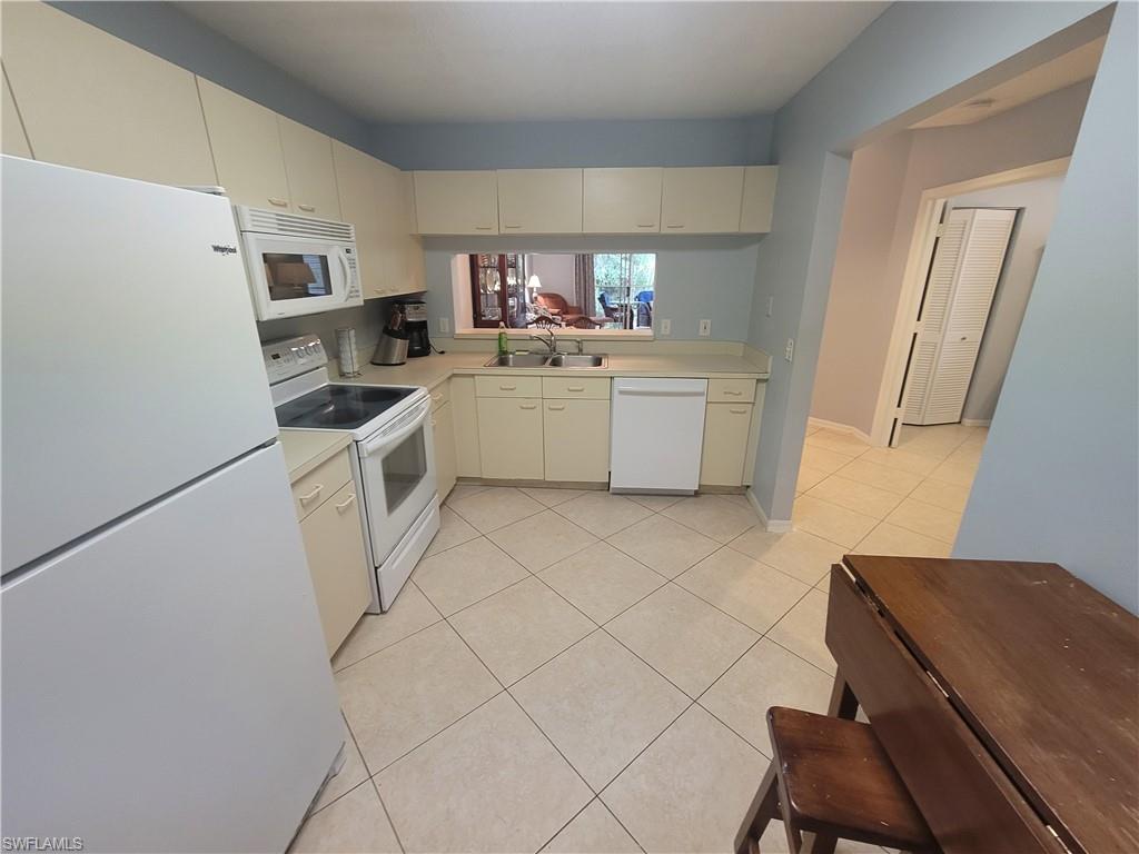 7731 Jewel Lane, Unit 204 Naples, FL 34109 - Photo 10 of 29 a kitchen with a sink and wooden floor