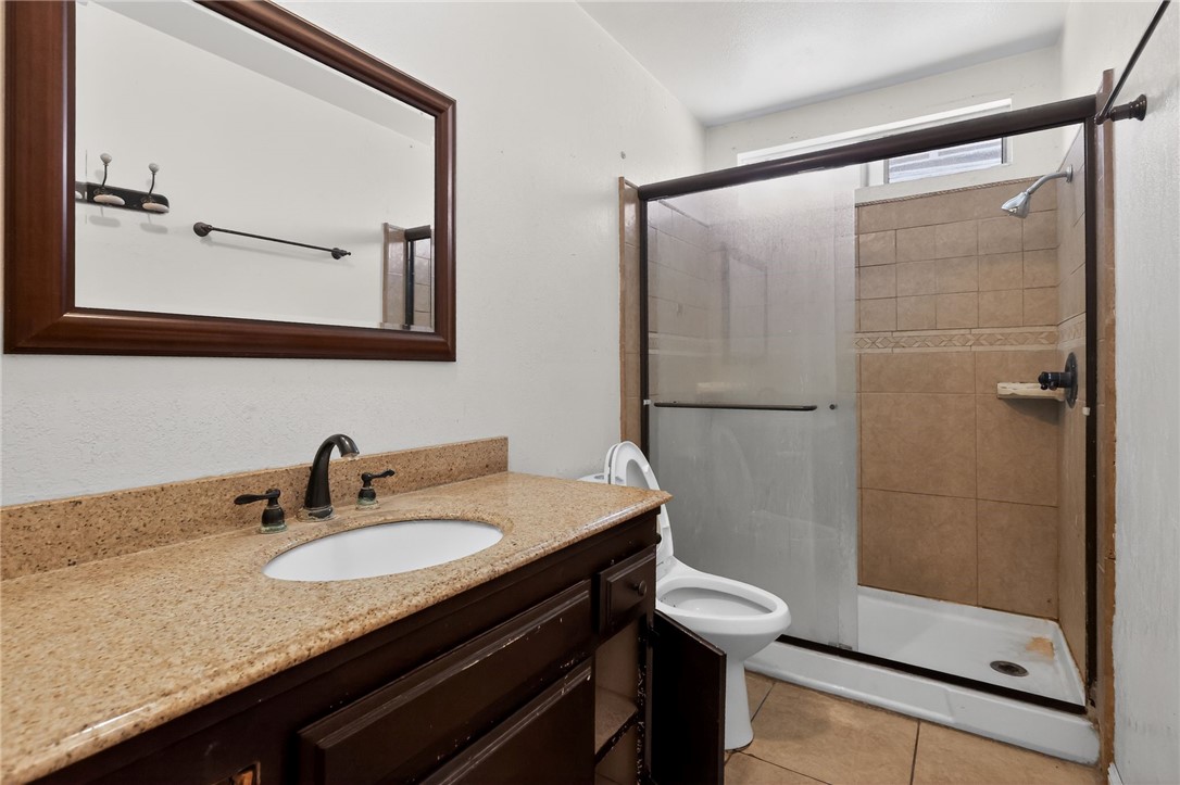 404 South 3rd Street Montebello, CA 90640 - Photo 10 of 29 a bathroom with a granite countertop sink mirror and a shower