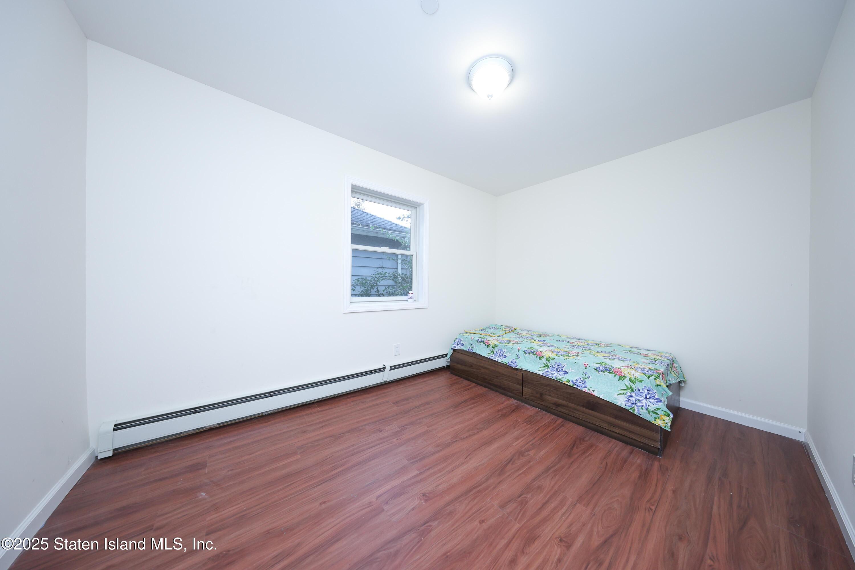 76 Simonson Avenue Staten Island, NY 10303 - Photo 12 of 21 an empty room with wooden floor and window