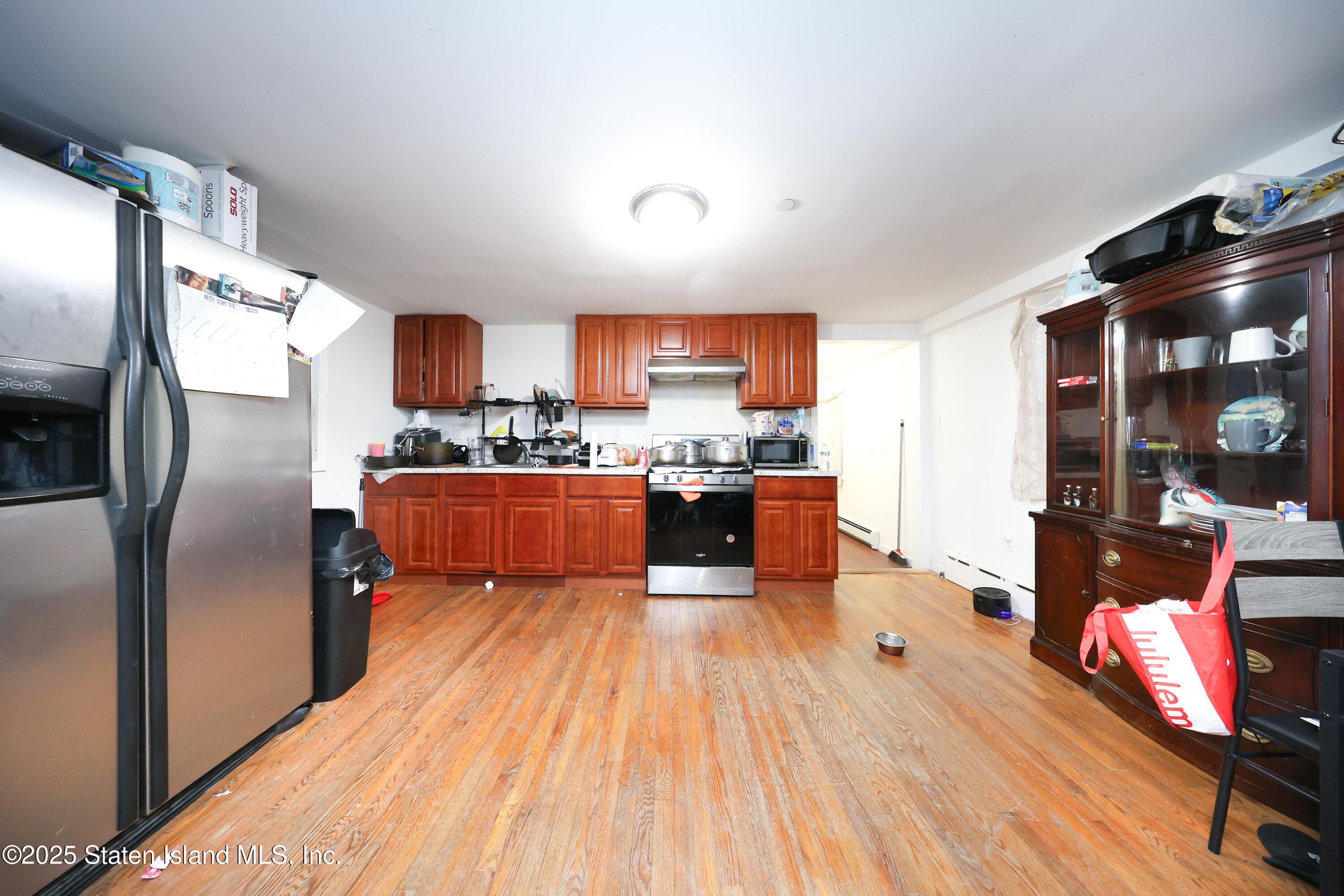 76 Simonson Avenue Staten Island, NY 10303 - Photo 4 of 21 a large kitchen with stainless steel appliances wooden floors and wooden cabinets