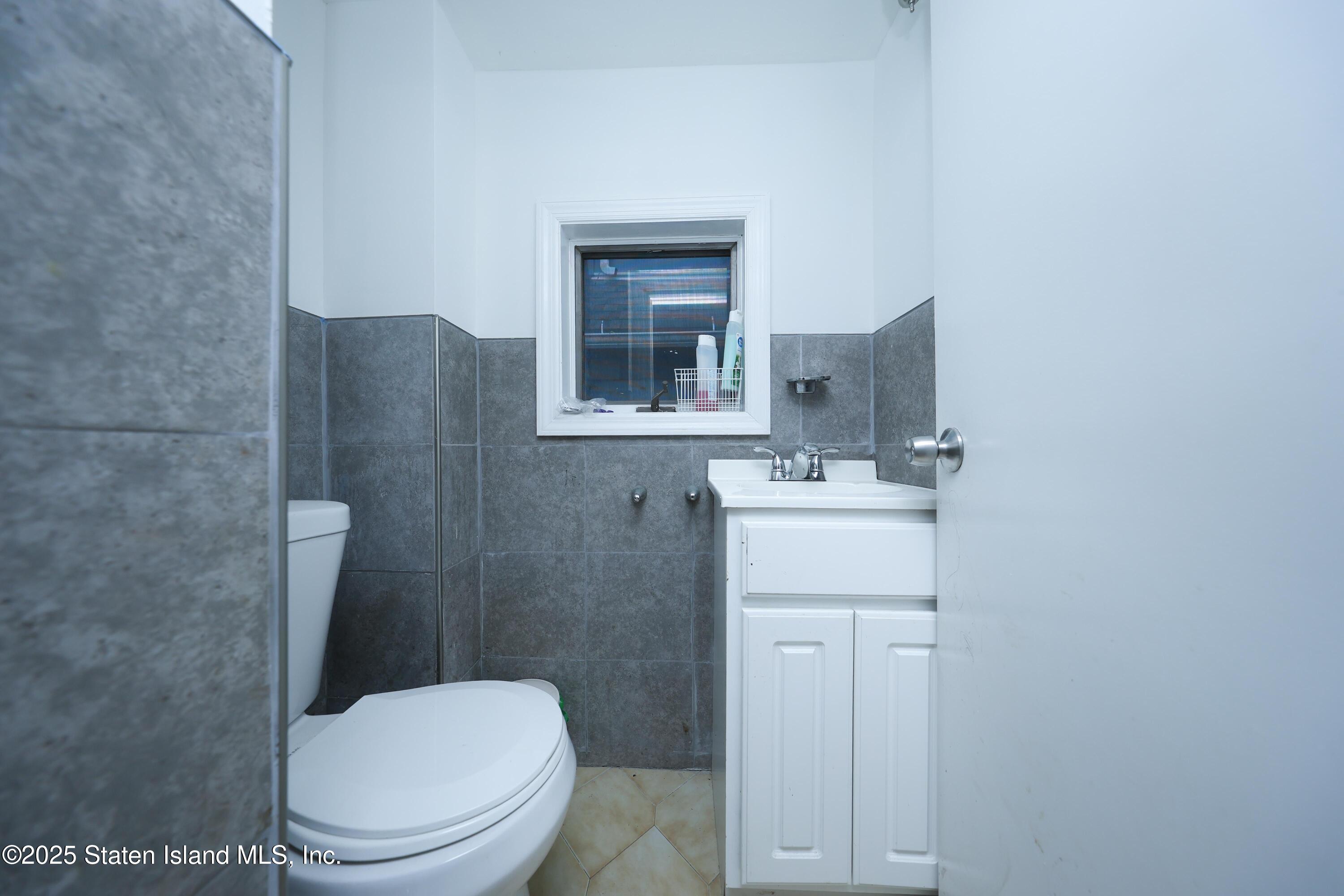 76 Simonson Avenue Staten Island, NY 10303 - Photo 10 of 21 a bathroom with a toilet sink and mirror