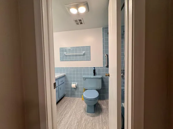 a bathroom with a granite countertop toilet sink and mirror