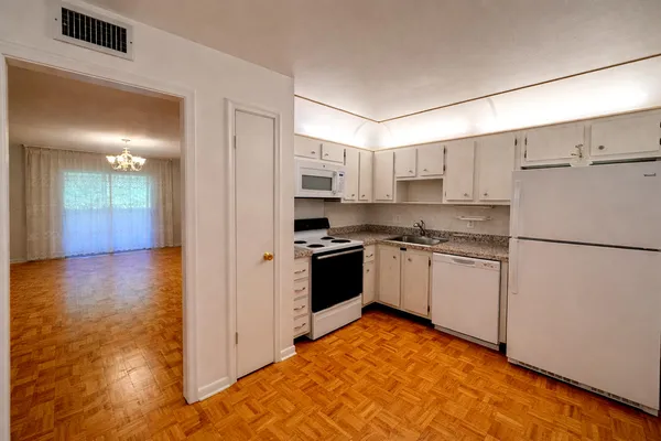 a kitchen with a refrigerator a stove top oven a sink and cabinets