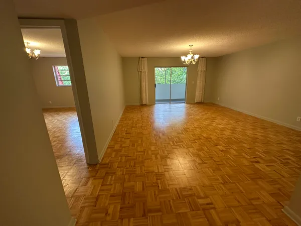 a view of an empty room with window and bathroom