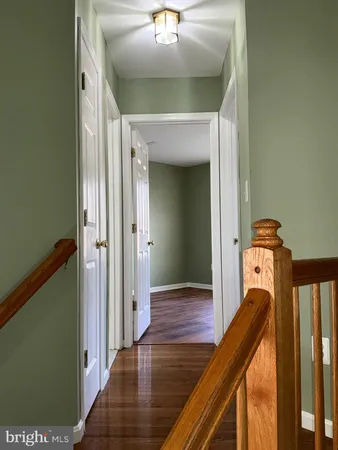 a view of a hallway with wooden floor and staircase