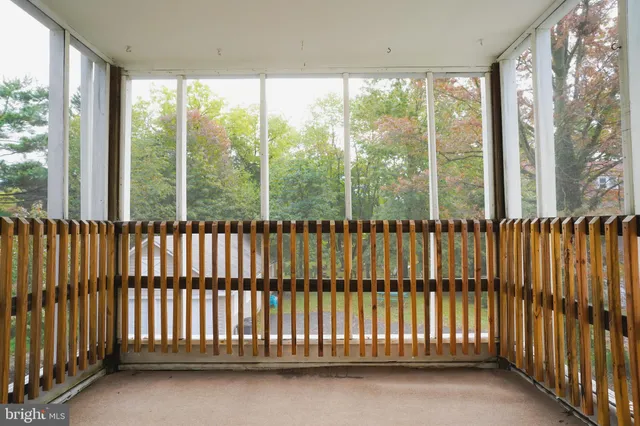 a view of a white house in front of a big yard with large trees