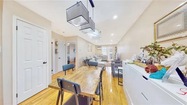 a view of a dining hall with a dining table chairs and couches with wooden floor