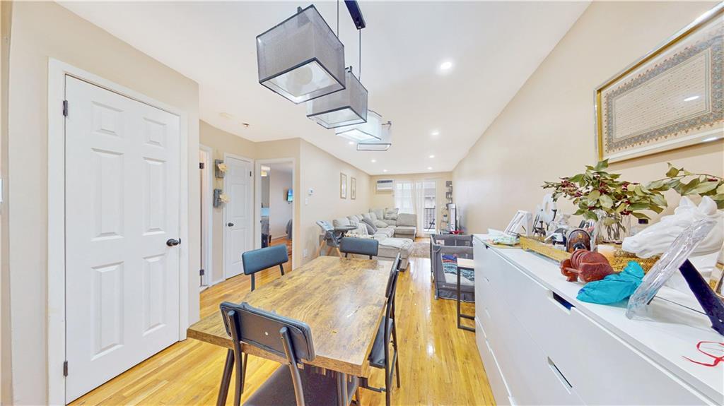 9729 4th Avenue, Unit 3C Brooklyn, NY 11209 - Photo 4 of 10 a view of a dining hall with a dining table chairs and couches with wooden floor