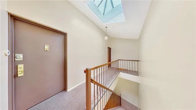a view of staircase with railing and white walls