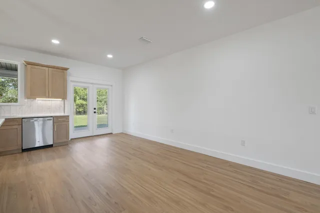 a kitchen with stainless steel appliances granite countertop a refrigerator a sink dishwasher a s stove top oven a large island with wooden cabinets and wooden floor