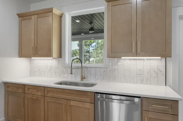 a kitchen with stainless steel appliances granite countertop a sink a stove and a wooden floors