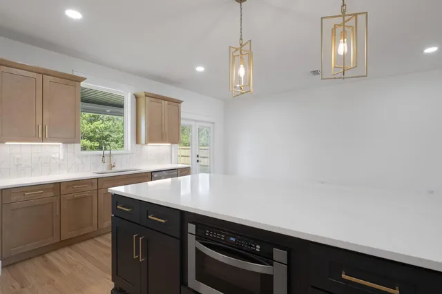 a view of a sink and dishwasher with wooden floor