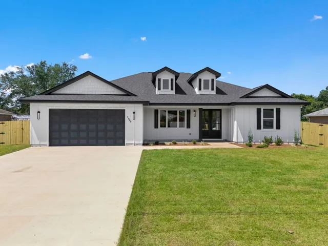 a front view of a house with a garden and yard