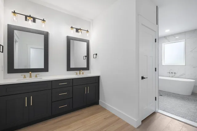 a bathroom with double sink and two mirror