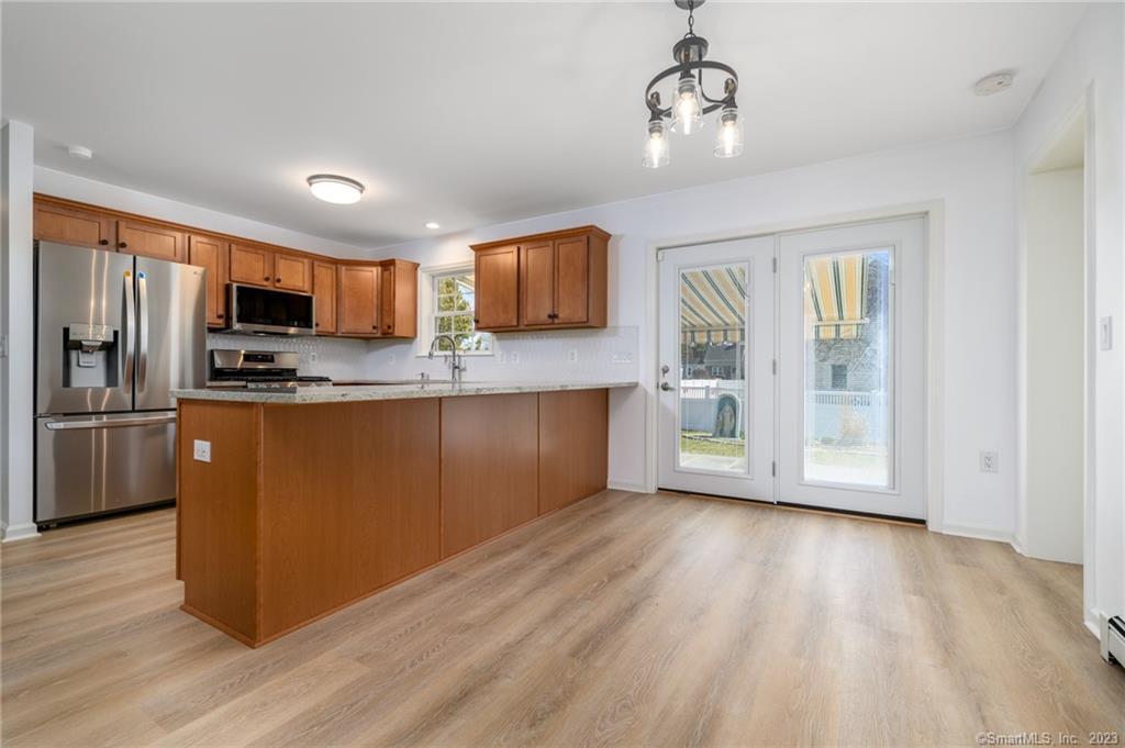 217 Highlawn Road Fairfield, CT 06824 - Photo 8 of 27 a kitchen with stainless steel appliances granite countertop a refrigerator a stove top oven a sink and dishwasher with wooden floor