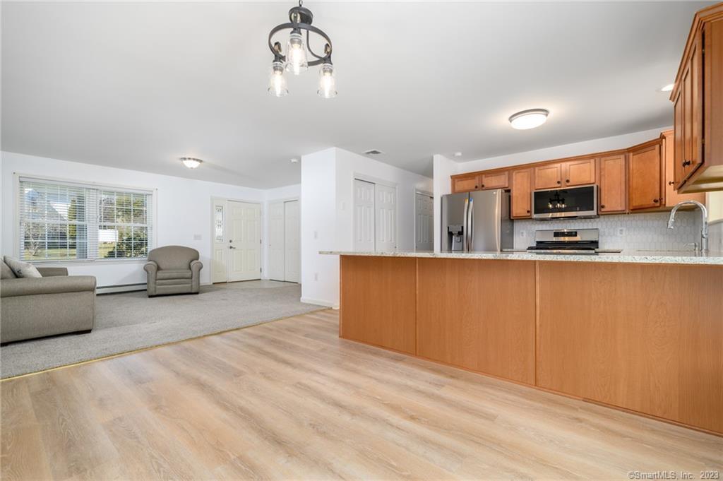 217 Highlawn Road Fairfield, CT 06824 - Photo 10 of 27 a living room with furniture a flat screen tv and kitchen view