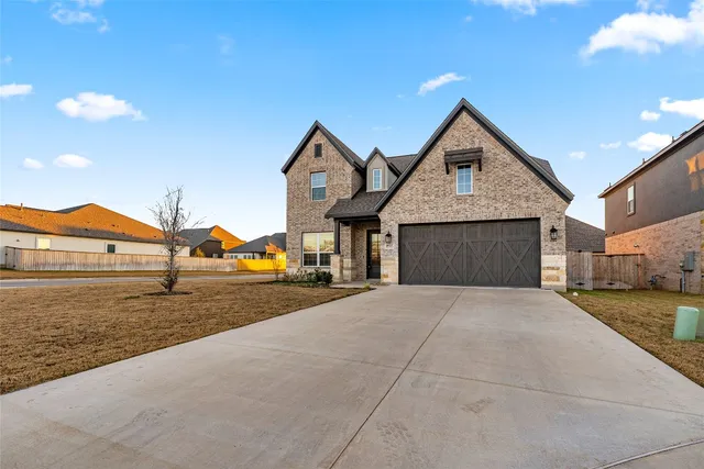 a view of a house with large space and a car park in front of it