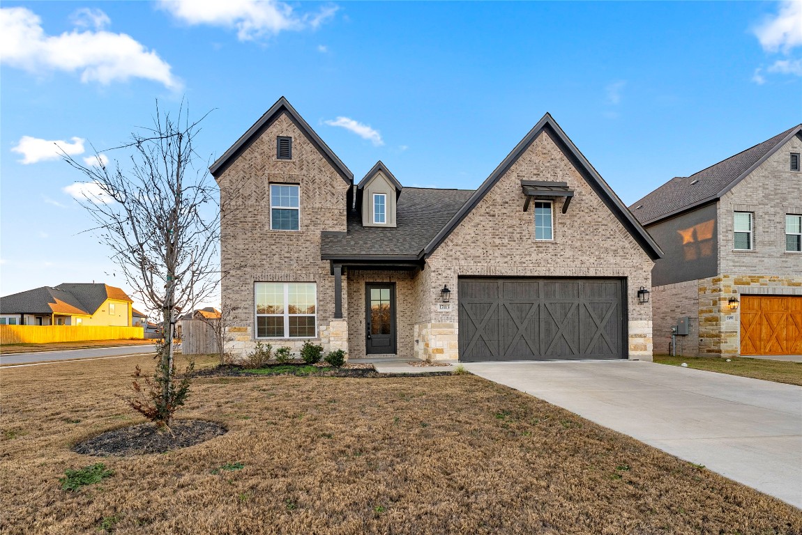 17113 Howdy Way Manor, TX 78653 - Photo 2 of 25 a front view of a house with a yard and garage
