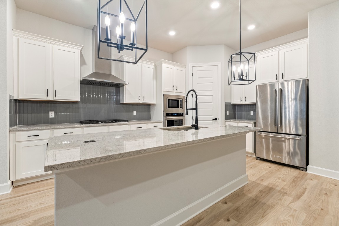 17113 Howdy Way Manor, TX 78653 - Photo 3 of 25 a kitchen with stainless steel appliances a refrigerator sink and white cabinets