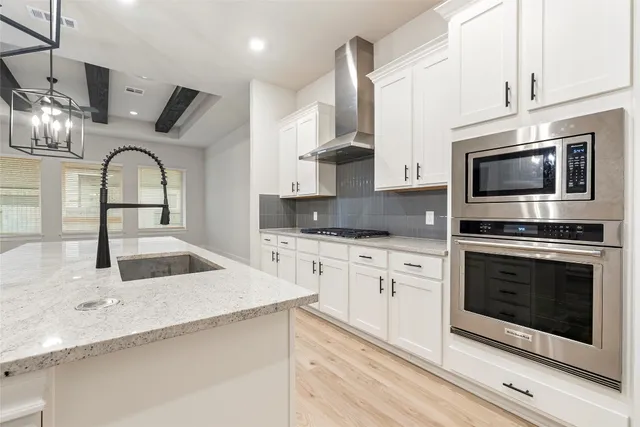 a kitchen with stainless steel appliances a refrigerator sink and white cabinets