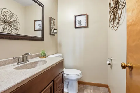 a bathroom with a granite countertop toilet sink and mirror