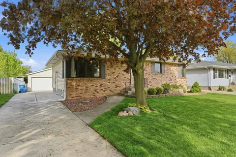 a front view of a house with a yard and trees