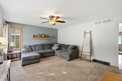 a living room with furniture a ceiling fan and a window