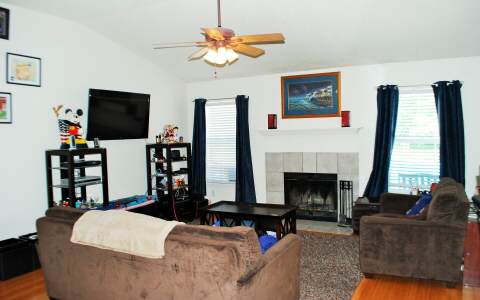 96456 Chester Road Yulee, FL 32097 - Photo 3 of 21 a living room with furniture a fireplace and a flat screen tv