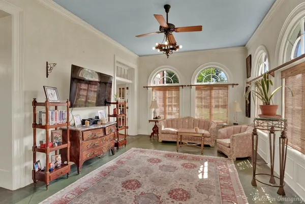 a living room with furniture a flat screen tv and a floor to ceiling window