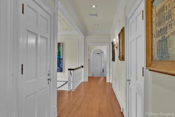 a view of a hallway with wooden floor and staircase