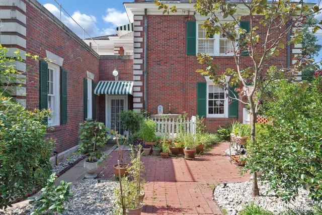 a front view of a multi story residential apartment building with yard and green space